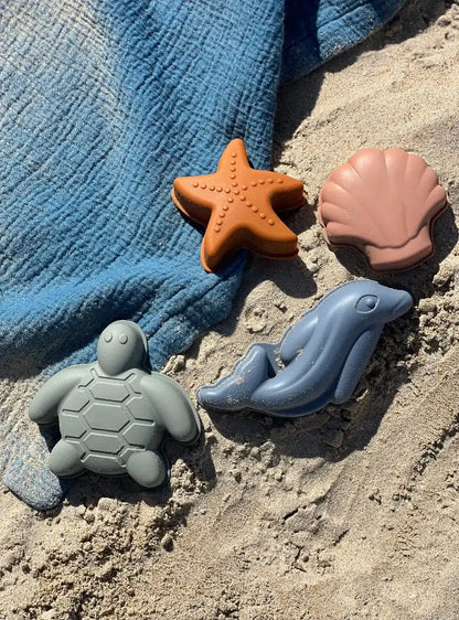 zandvormpjes zandkoekjes maken silicone flexibele strandvormpjes zeester dolfijn schildpad schelp in netje strandspeelgoed play and store bovenaanzicht