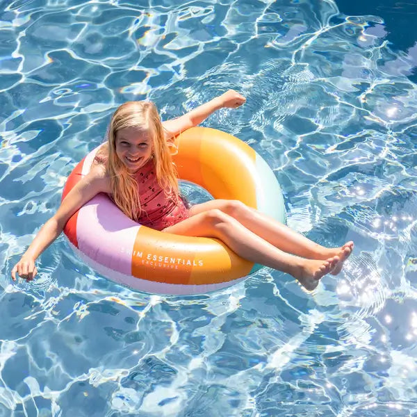 zwemband zomer kinderen meisjes regenboog swim essentials zwembad artikelen opblaasspeelgoed sfeerfoto meisje in zwembad